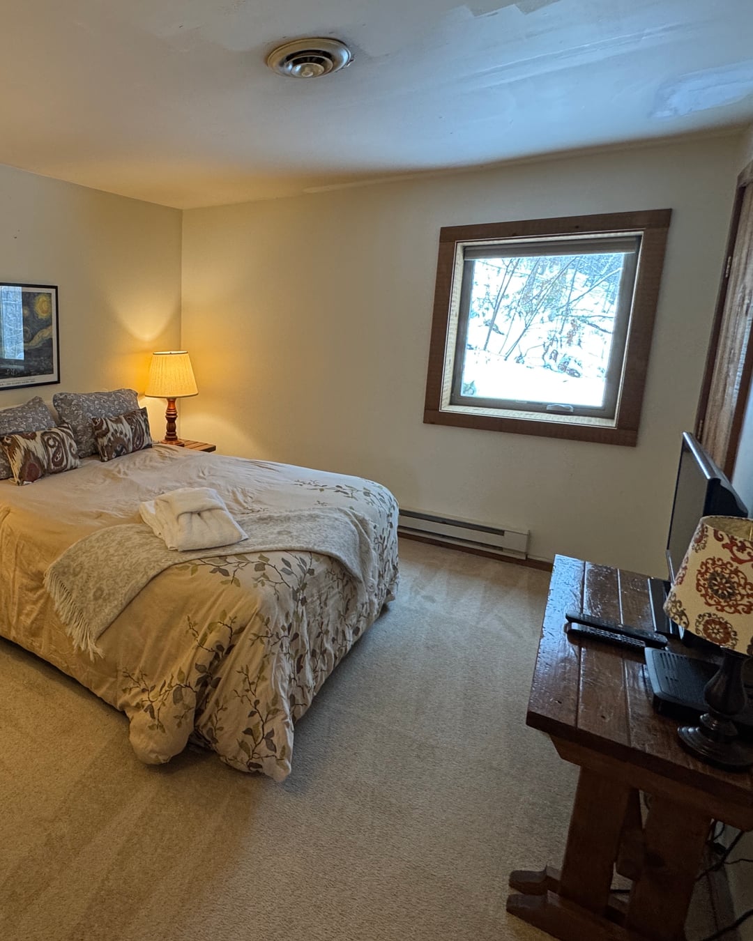 Bedroom 3: a queen bed with a window onto snowy woods.