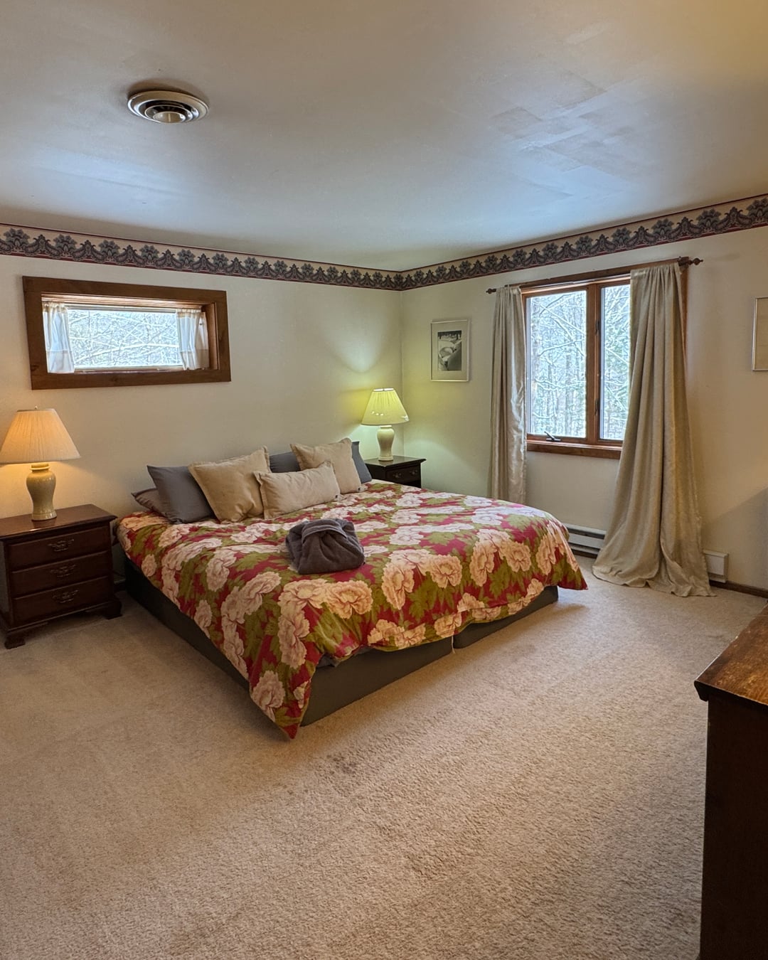 Bedroom 2: a king bed between curtained windows.