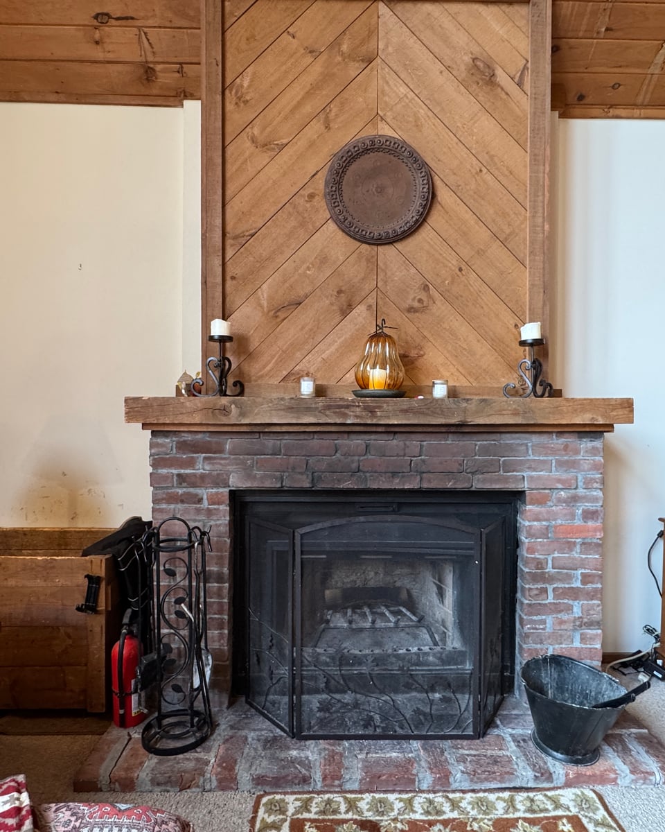 The brick fireplace with its herringbone pine chimney panel.