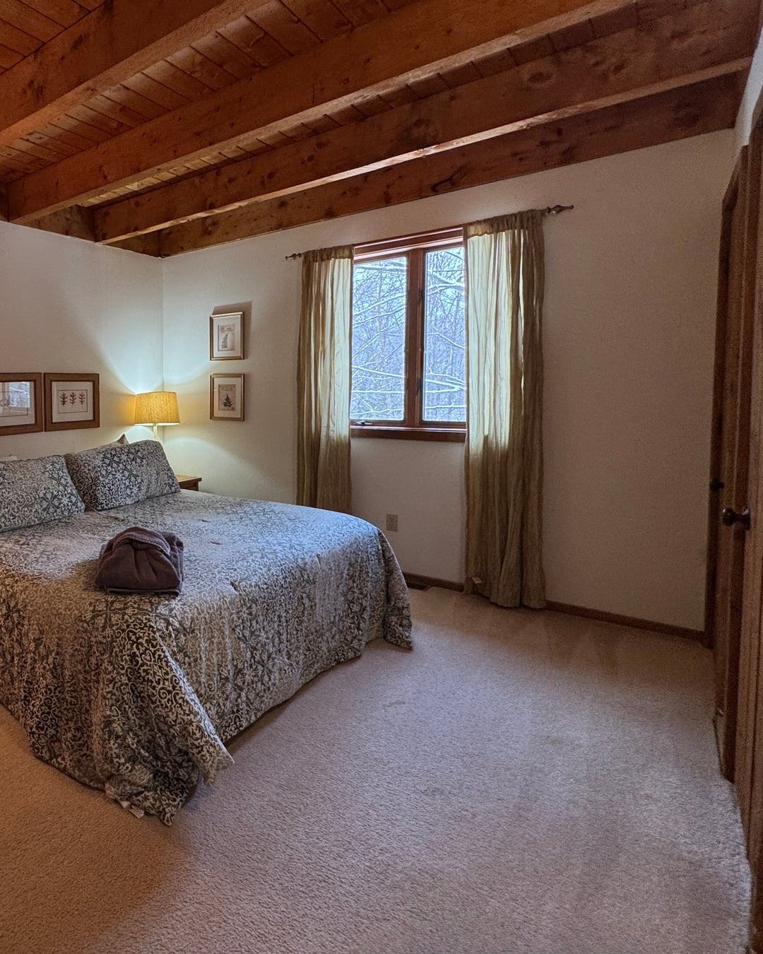 Bedroom 1: a king bed under a beamed ceiling.