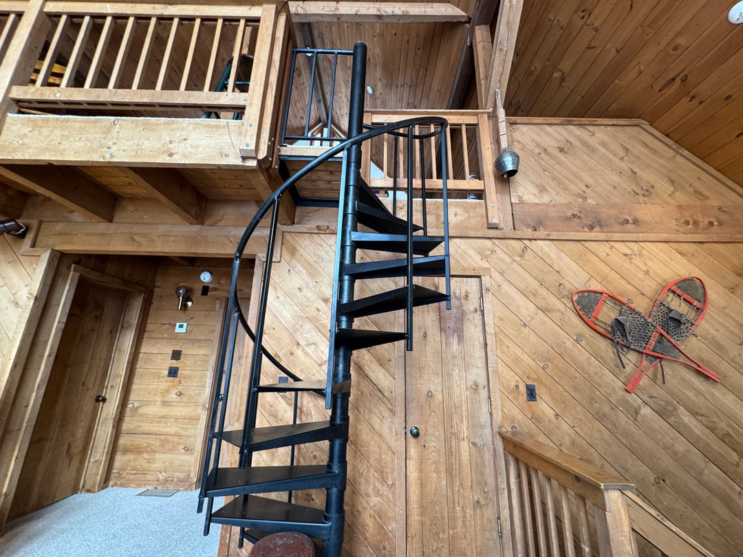 Great room: Overhead from the loft looking down the spiral stair to the pine floor and snowshoe decor