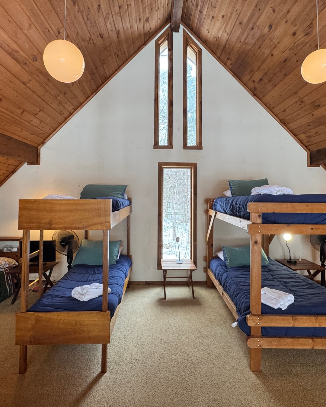 The loft gable end: bunk beds either side of slim windows under the A-frame roof.